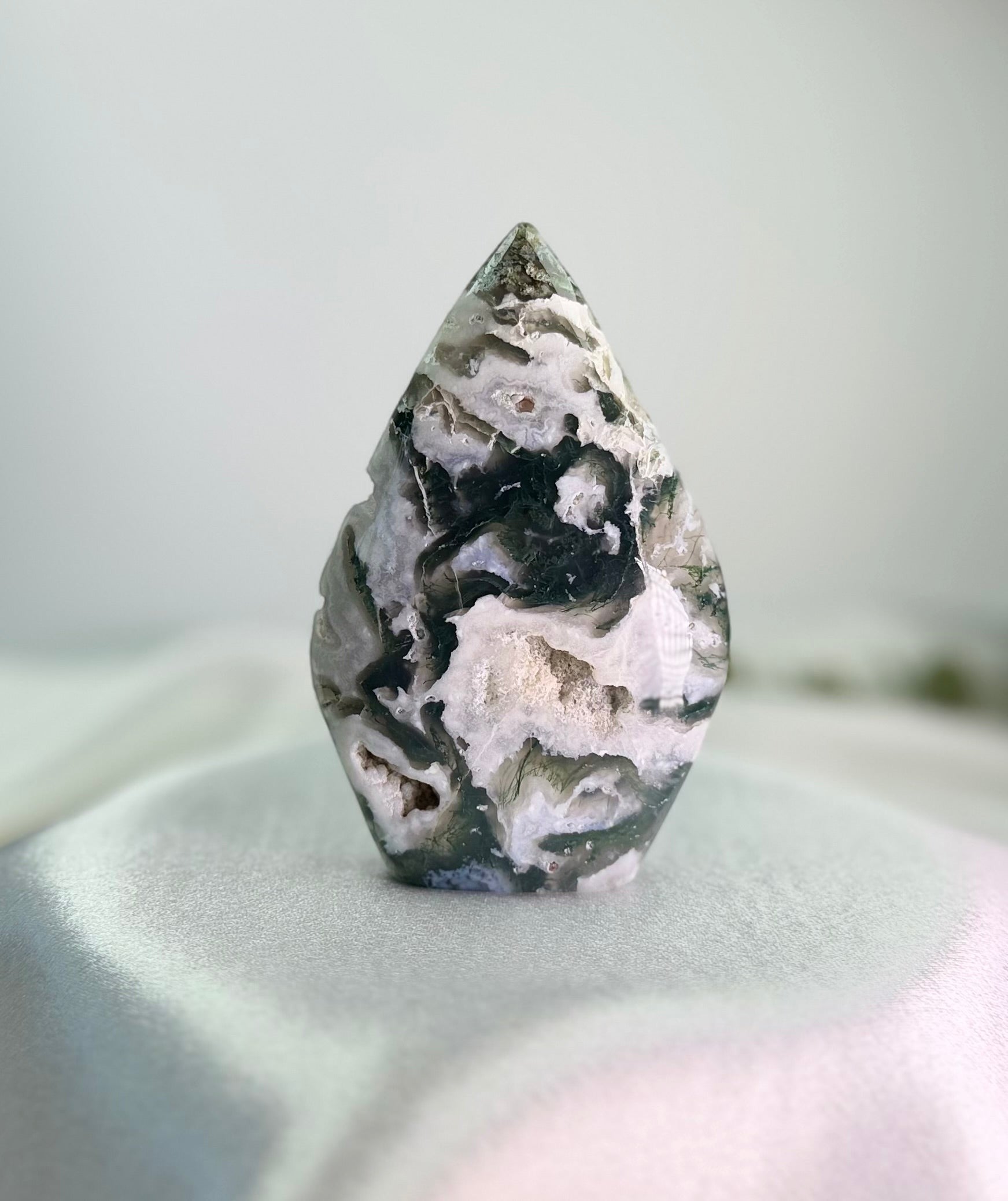 Treasured Energies polished moss agate flame crystal sculpture with green and white mineral inclusions and druzy pockets.