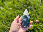 Treasured Energies hand-polished moss agate freeform crystal with green and white earthy inclusions held in a palm