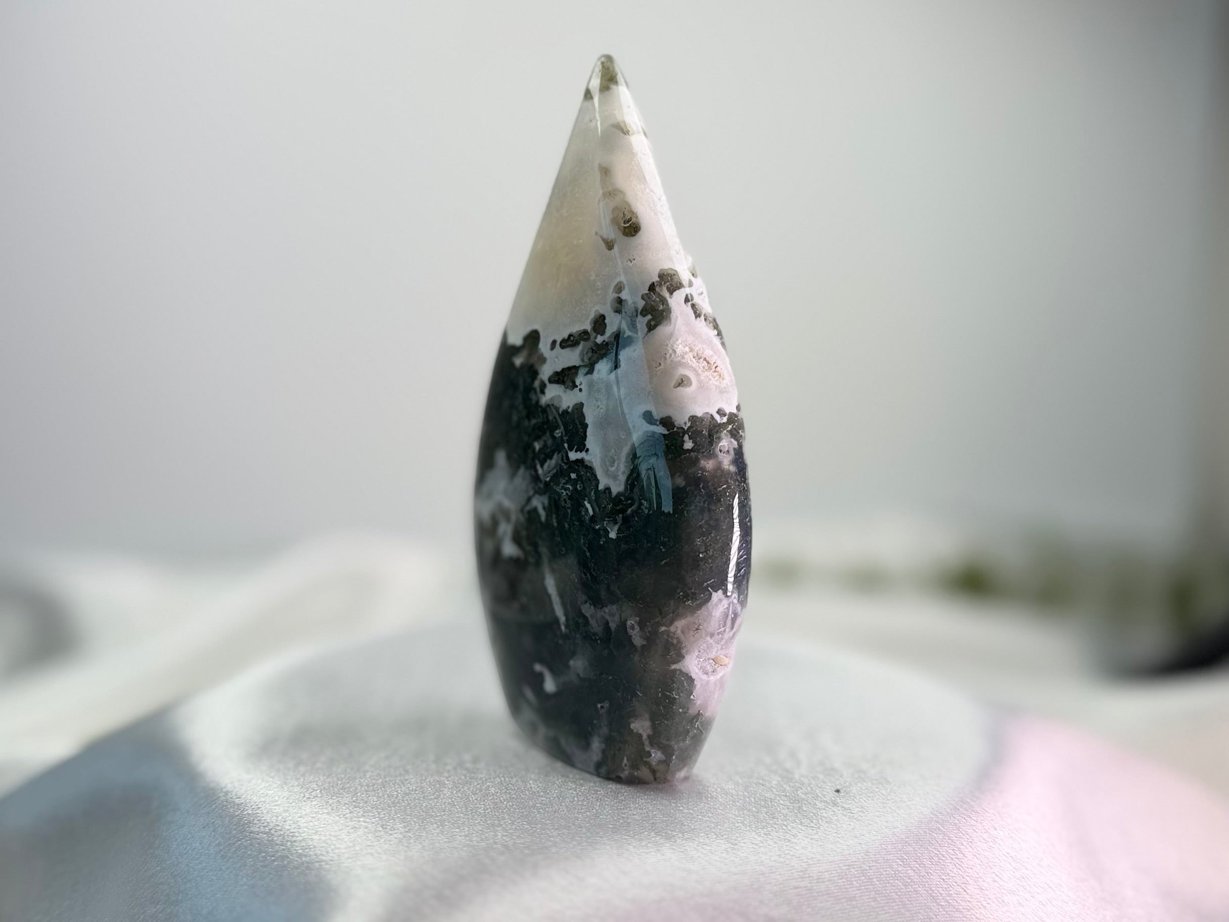 Treasured Energies polished Moss Agate freeform crystal with dark green inclusions and a smooth, sculptural shape.