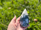 Treasured Energies hand-polished Moss Agate freeform crystal with green and white organic patterns held in a hand.