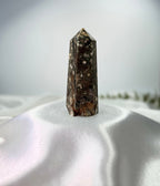Treasured Energies polished Ocean Jasper crystal tower with natural orbicular patterns on a white satin background