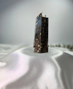 Treasured Energies polished Ocean Jasper crystal tower with dark brown tones and orbicular patterns on white silk.