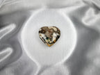 Treasured Energies large heart-shaped Ocean Jasper crystal with unique earthy patterns on a smooth silver satin background.