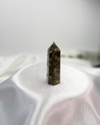 Treasured Energies dark brown Ocean Jasper crystal tower with unique orbicular patterns on a white satin background.