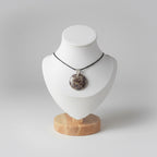 Treasured Energies polished orbicular poppy jasper pendant with brown tan spots on a black cord displayed on a white bust