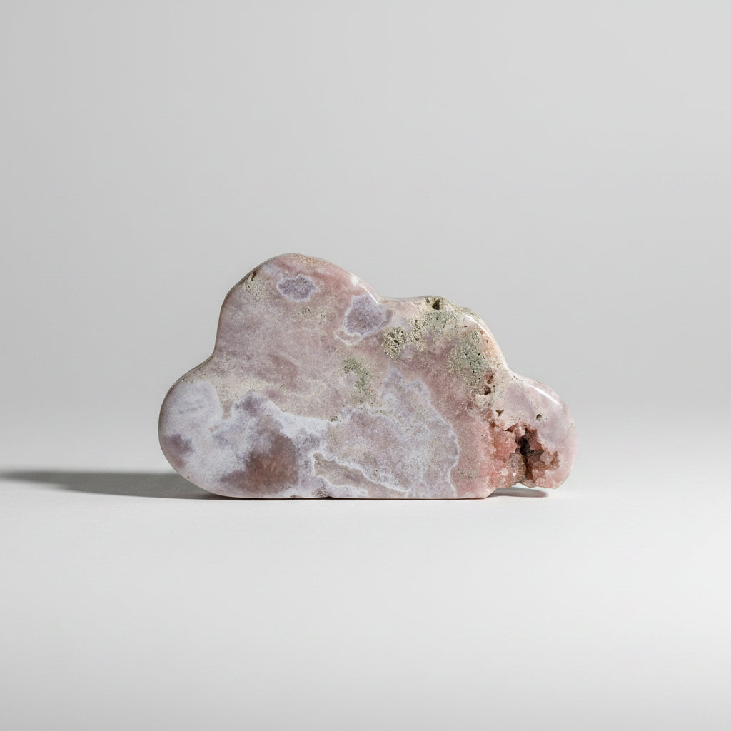 Treasured Energies pink amethyst crystal specimen carved into a soft cloud shape with natural mineral textures.