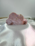 Treasured Energies pink amethyst crystal carved into a smooth cloud shape, displaying soft pink and white mineral tones.