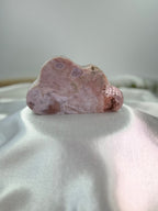Treasured Energies pink amethyst crystal carved into a smooth cloud shape, displaying soft pink and white mineral tones.