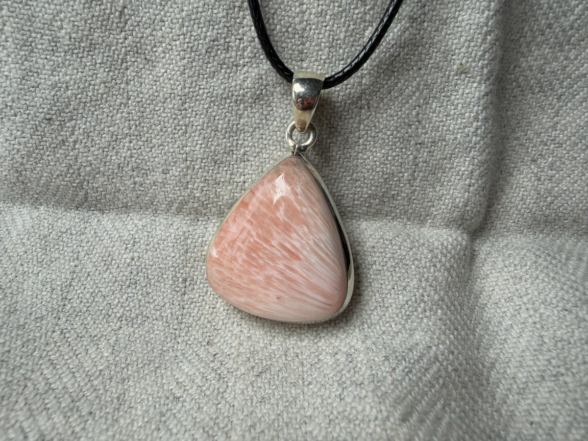 Treasured Energies teardrop pink gemstone pendant with white fibrous inclusions in a sterling silver setting on black cord