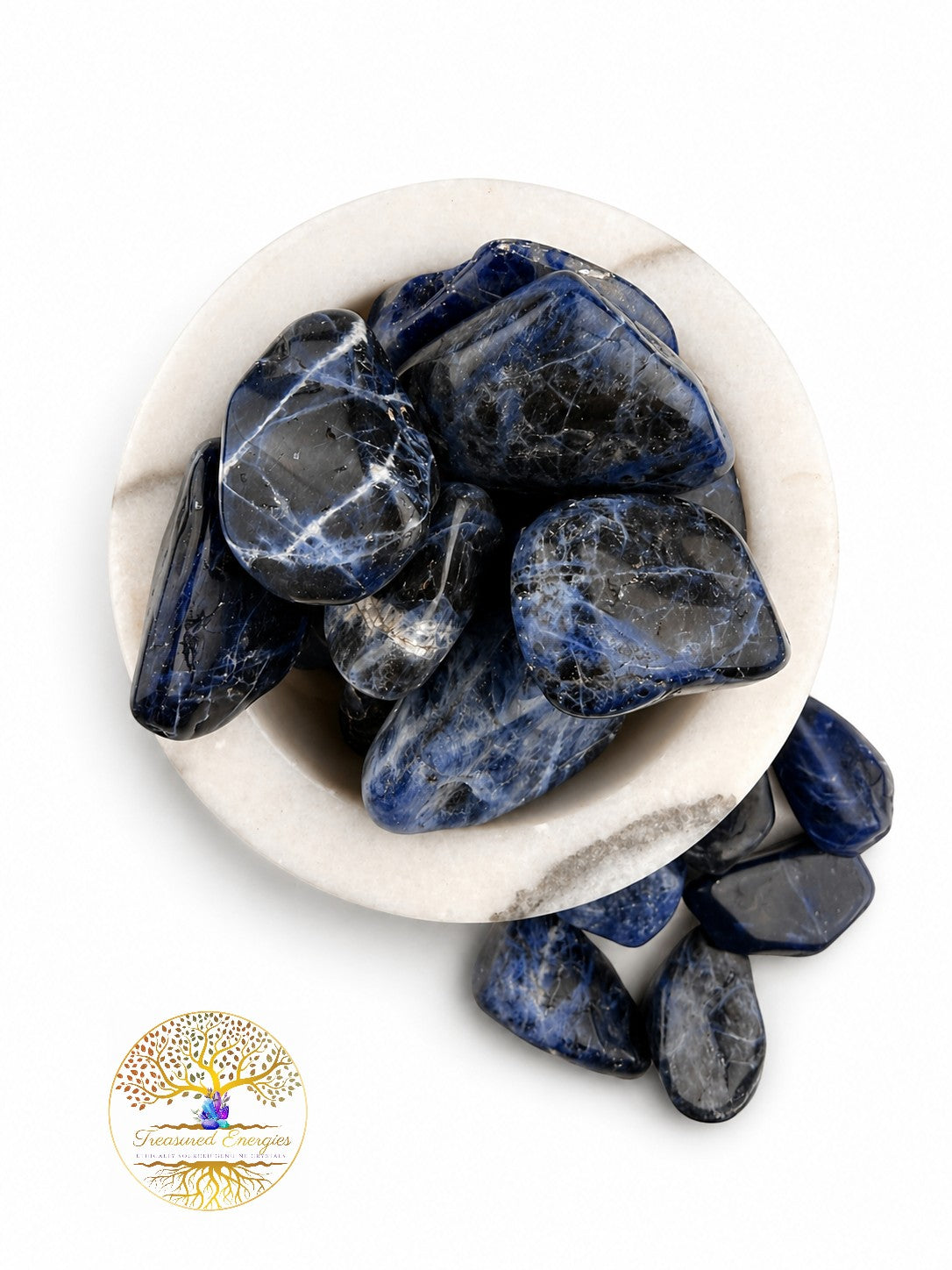 Treasured Energies polished royal blue sodalite tumbled stones with white calcite veins in a marble bowl.