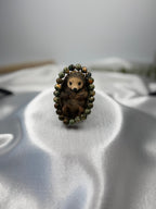 Treasured Energies rhyolite beaded elastic bracelet featuring a cute sculpted hedgehog centerpiece on satin fabric.
