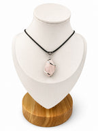 Treasured Energies rose quartz crystal pendant wrapped in silver wire on a black cord necklace displayed on a bust.