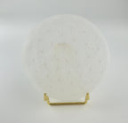 Treasured Energies 8cm round white selenite charging plate with a sacred geometry flower of life engraving on a stand