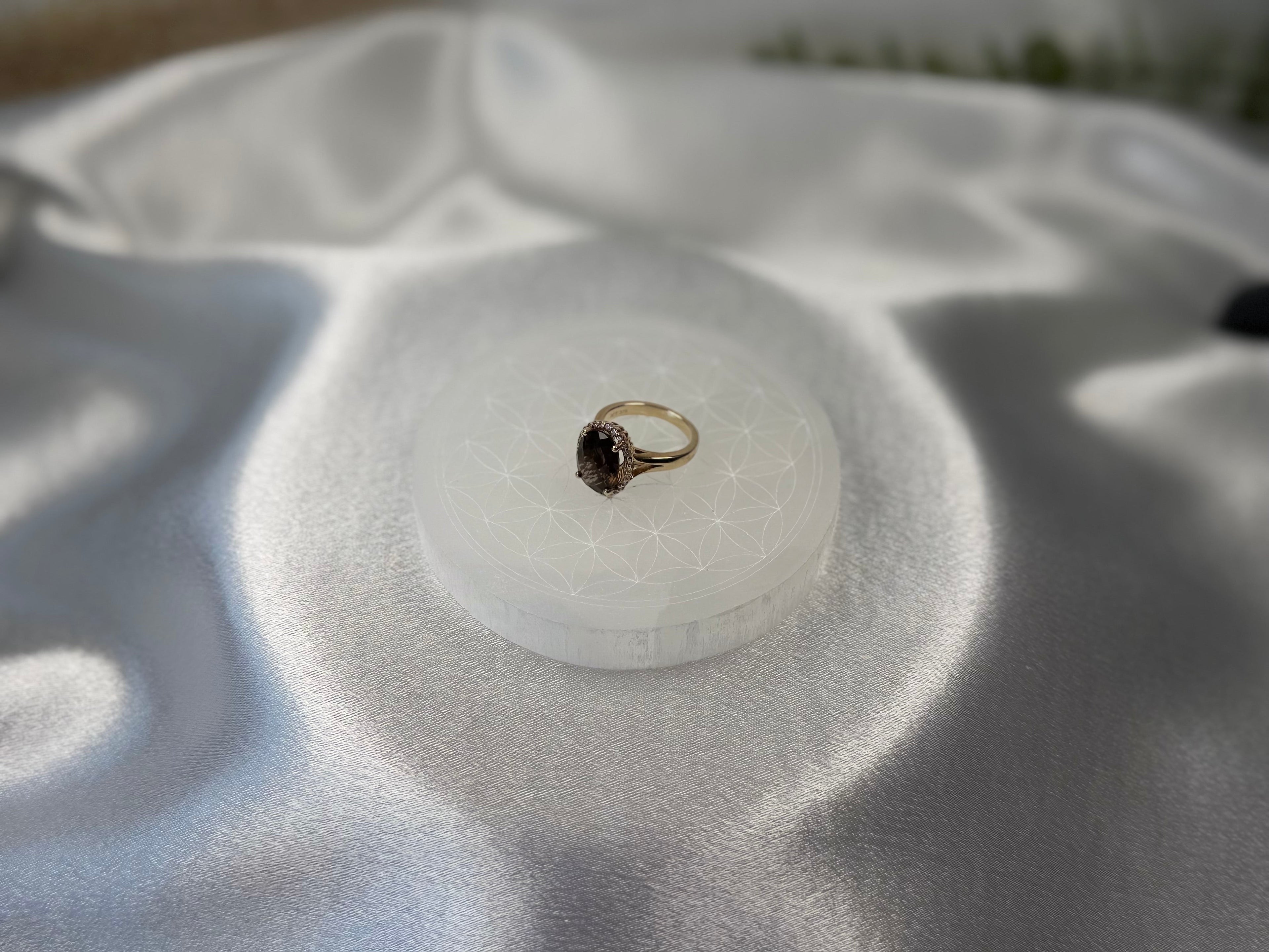 Treasured Energies 8cm round white selenite charging plate with sacred geometry engraving holding a gold ring