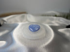 Treasured Energies 8cm round selenite charging plate with sacred geometry engraving holding a blue heart crystal