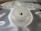 Treasured Energies hand carved white selenite crystal bowl holding a gold gemstone ring on a satin fabric background