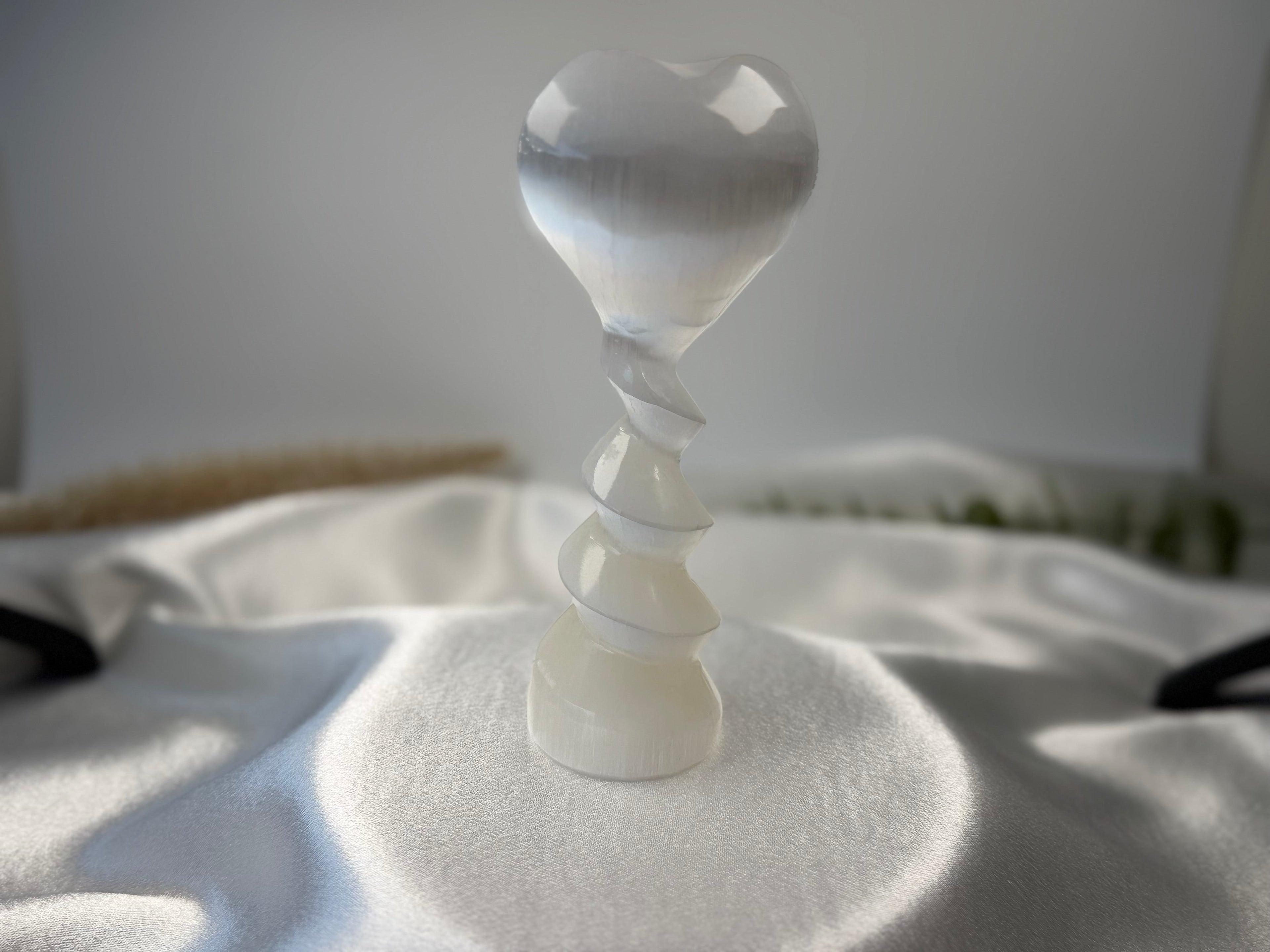 Treasured Energies translucent white selenite crystal heart sculpture with a decorative spiral pedestal base