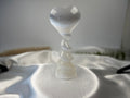 Treasured Energies white selenite crystal heart sculpture with a spiral pedestal base on a satin fabric surface