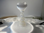 Treasured Energies white selenite crystal heart sculpture with a spiral pedestal base on a satin fabric surface
