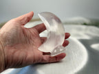 Treasured Energies hand-carved translucent white selenite crescent moon crystal sculpture held in a palm