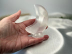 Treasured Energies hand carved translucent white selenite crescent moon crystal sculpture held in a palm