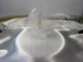 Treasured Energies hand-carved translucent white selenite crescent moon crystal sculpture on a satin fabric background.