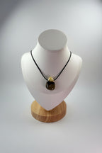 Treasured Energies Septarian crystal pendant on a black cord necklace displayed on a white mannequin bust.