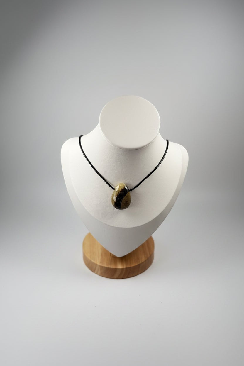 Treasured Energies polished Septarian pendant necklace on a black cord displayed on a white mannequin bust.