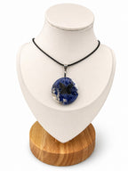 Treasured Energies sodalite donut ring necklace with a black butterfly pendant on a black cord, displayed on a bust.