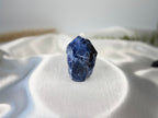 Treasured Energies Sodalite crystal tower with a polished point and raw base on a white satin background