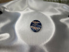 Treasured Energies smooth oval Sodalite crystal worry stone with deep blue and white mineral patterns on a satin fabric.