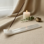 Selenite incense holder styled on warm linen with eucalyptus and candlelight