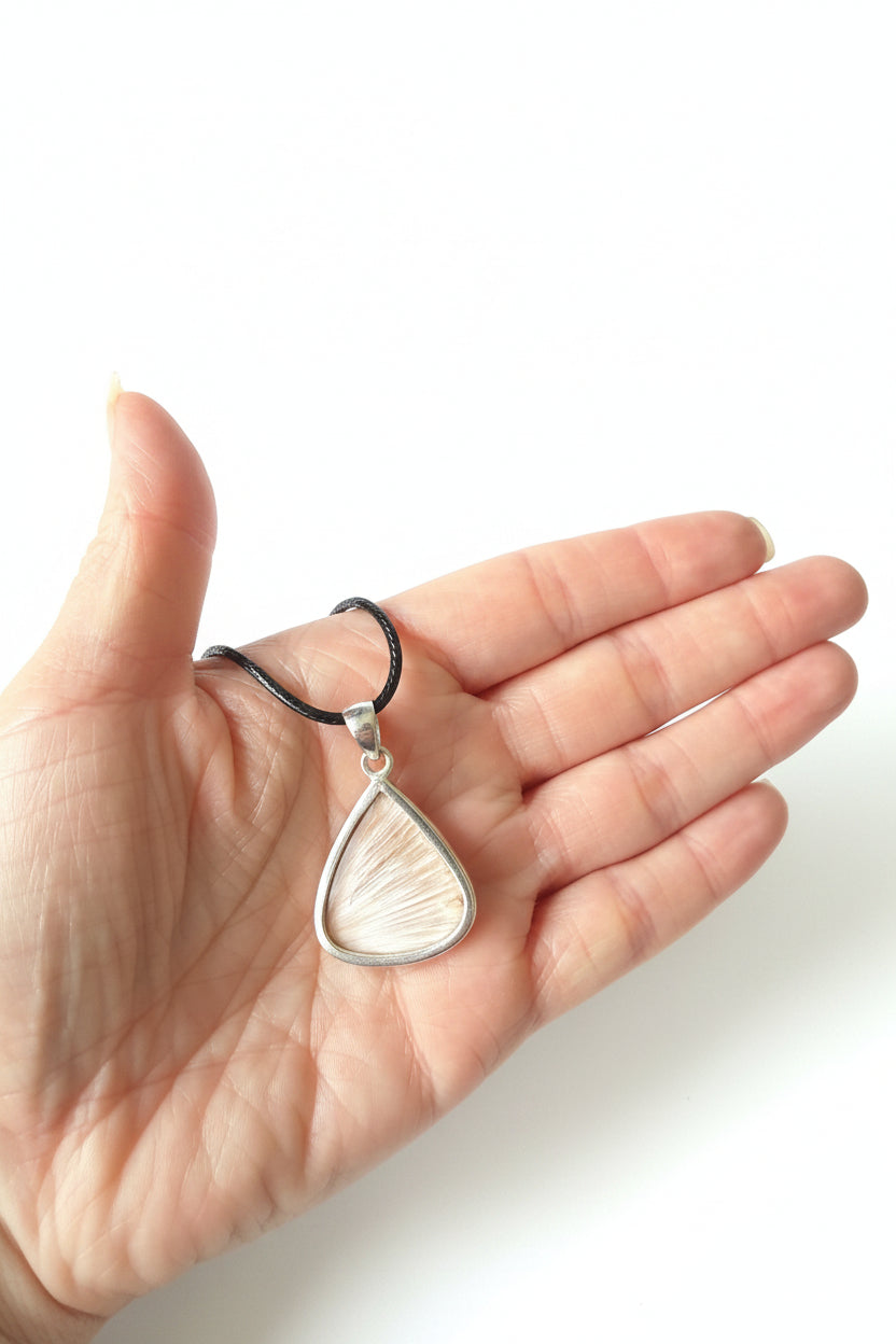 Treasured Energies teardrop pendant necklace with a textured natural fibre inlay in a silver-tone setting on black cord