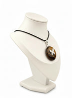Treasured Energies Tiger Eye donut ring necklace with a silver butterfly pendant on a black cord, displayed on a bust.