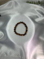 Treasured Energies gold tiger eye crystal bead bracelet on a soft white satin background