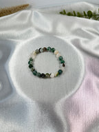 Treasured Energies tree agate crystal bead bracelet on a white satin background for healing and inner peace