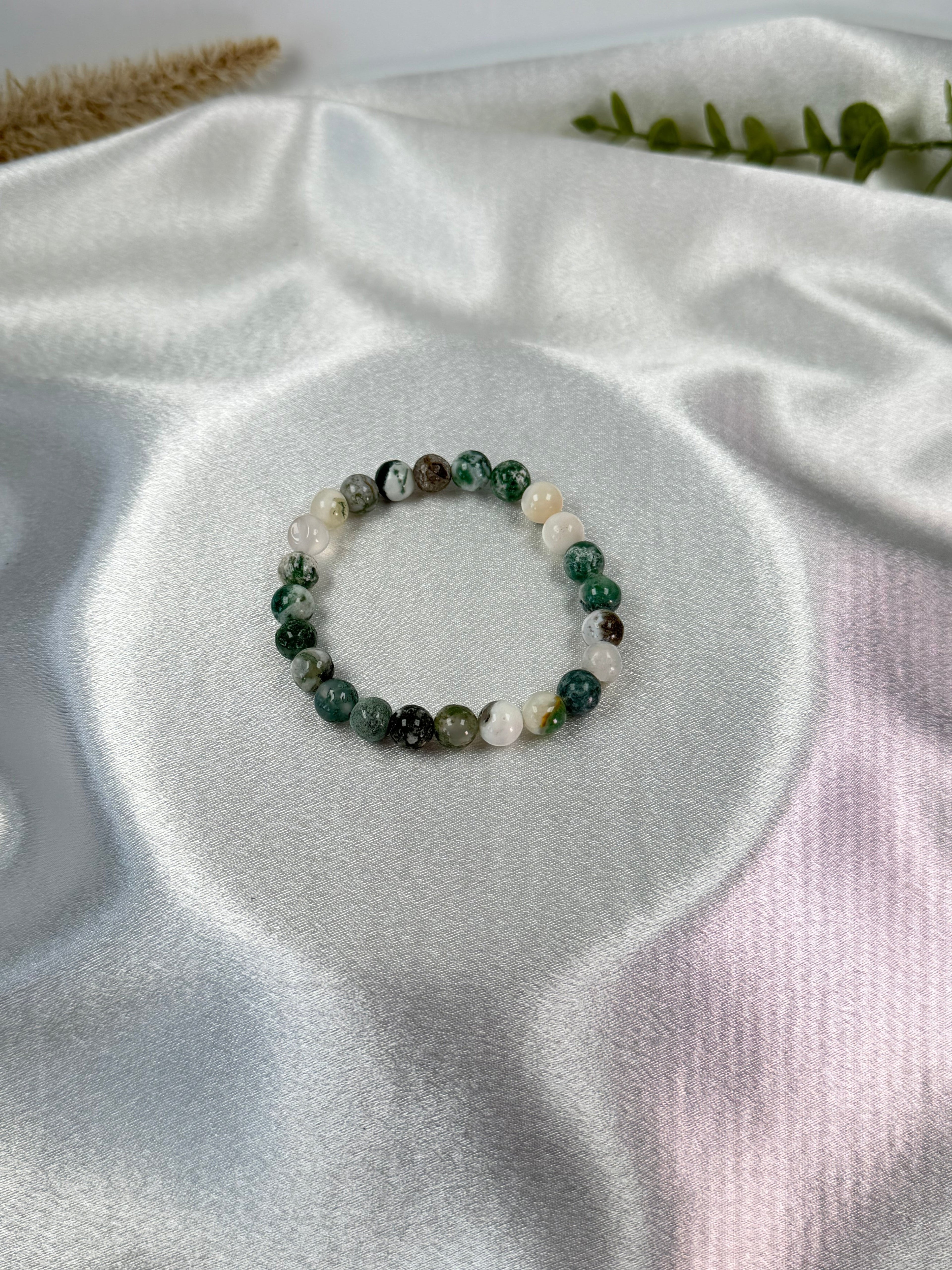 Treasured Energies tree agate crystal bead bracelet on a white satin background for healing and inner peace