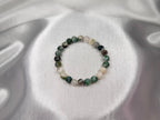 Treasured Energies tree agate crystal bead bracelet on a shimmering silver satin background