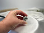 Treasured Energies polished Tree Agate crystal held in a hand, showing white stone with dark green dendritic patterns.