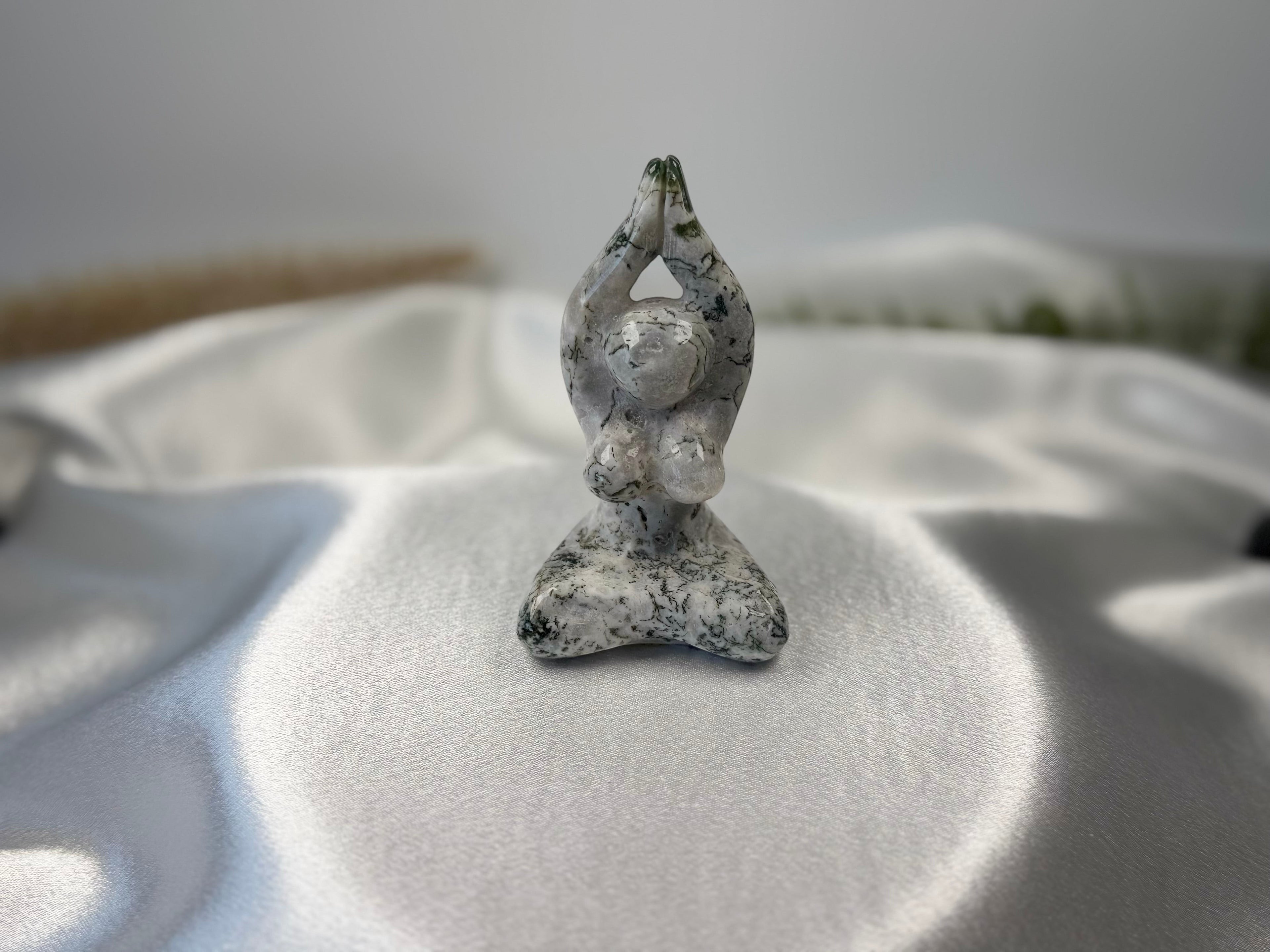 Treasured Energies Tree Agate carving of a woman in a yoga pose with white and green dendritic patterns