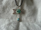 Treasured Energies Triple Moon pendant necklace with a turquoise stone and dangling teardrop on a black cord