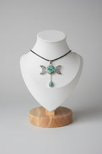 Treasured Energies Triple Moon Goddess pendant necklace featuring a turquoise stone and teardrop on a black cord.