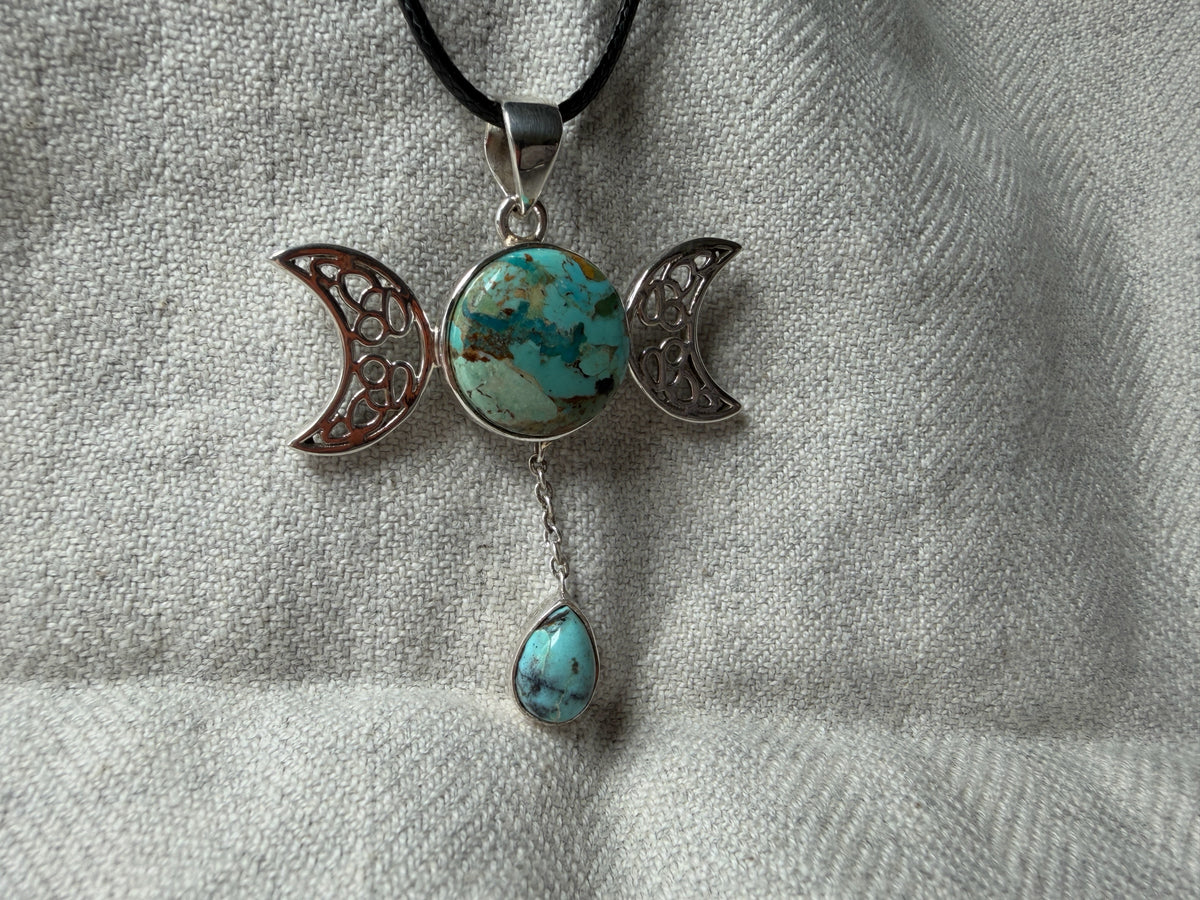 Treasured Energies Triple Moon Goddess pendant necklace featuring a turquoise stone on a black cord.