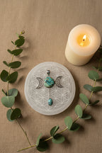 Treasured Energies Triple Moon Goddess pendant necklace with turquoise stones on a black cord over a crystal grid