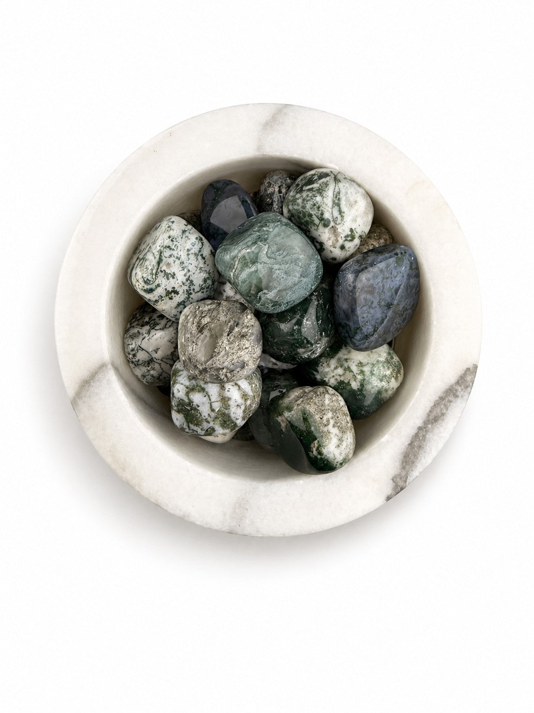 Treasured Energies tumbled Tree Agate crystals with green and white dendritic patterns in a white marble bowl.