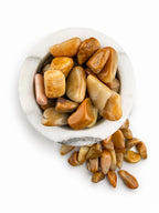 Treasured Energies yellow aventurine tumbled stones in a white marble bowl, showcasing golden hues and smooth texture.