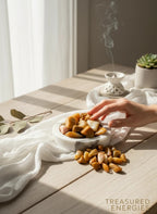 Treasured Energies yellow aventurine tumbled stones in a marble bowl on a sunlit table with incense smoke