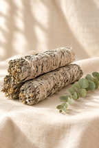 White sage bundles styled on warm ivory linen