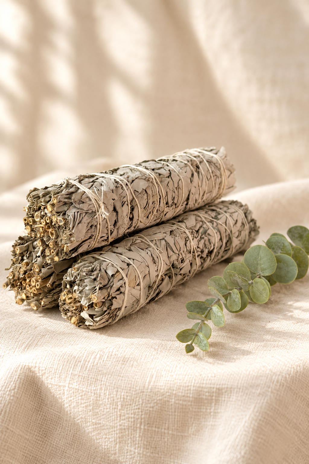White sage bundles styled on warm ivory linen